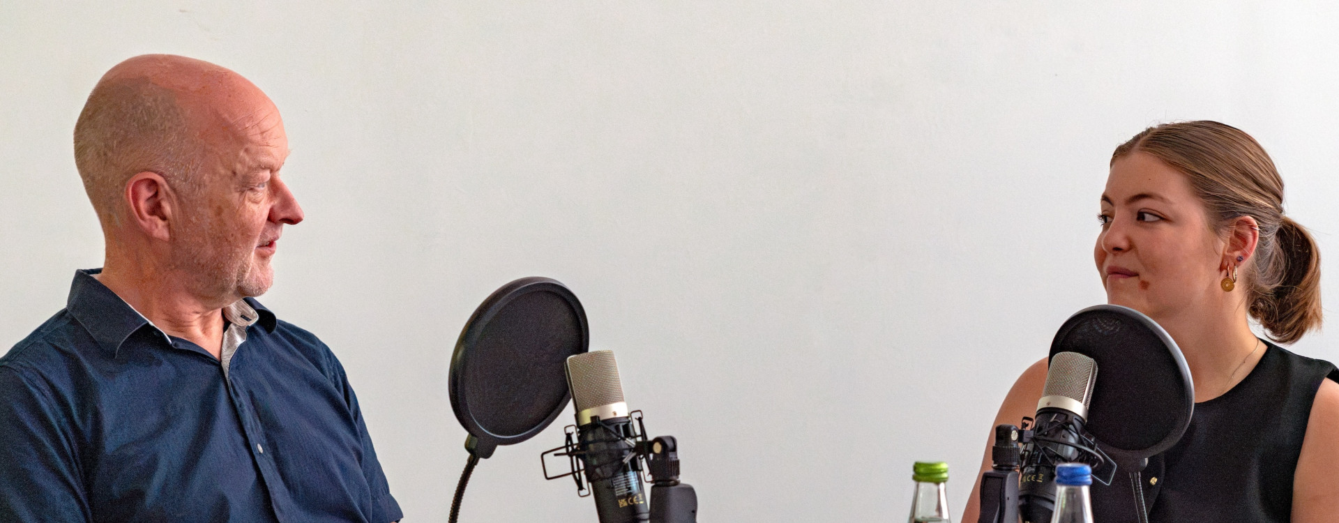Zwei Personen sitzen bei einer Podcastaufnahme