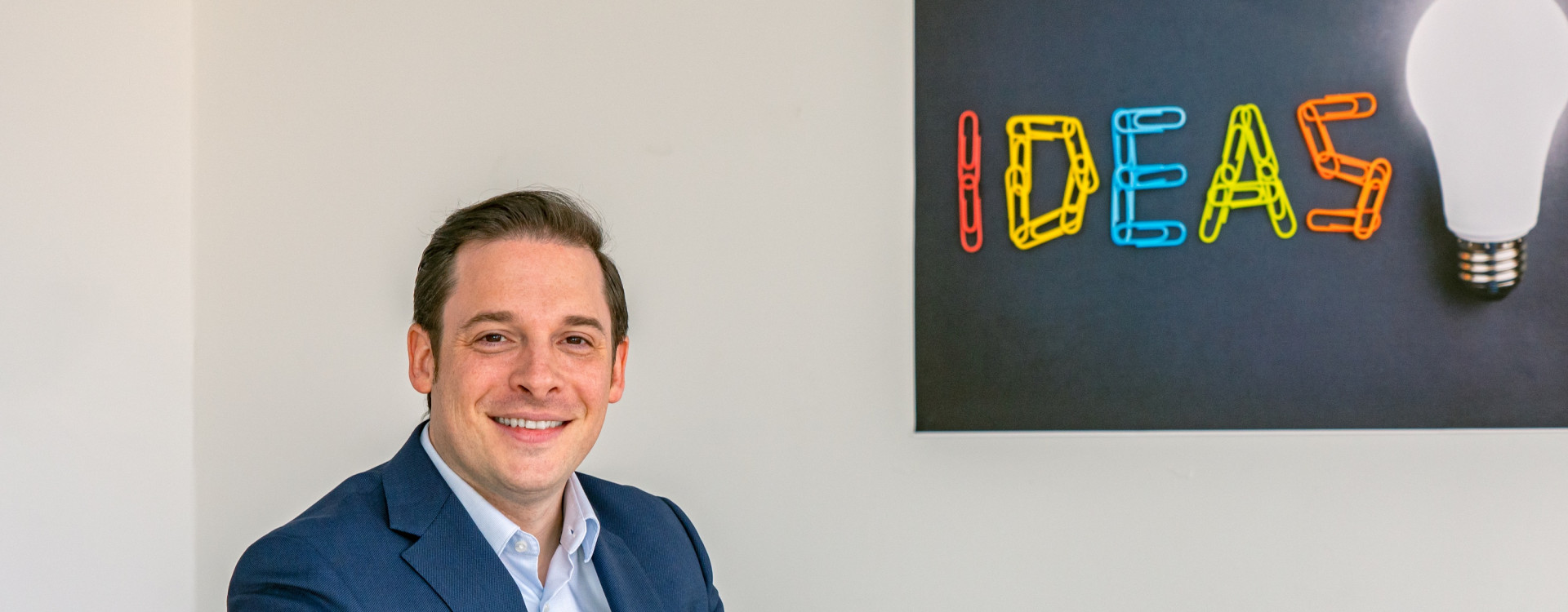 Mann im Anzug sitzt an einem weißen Tisch