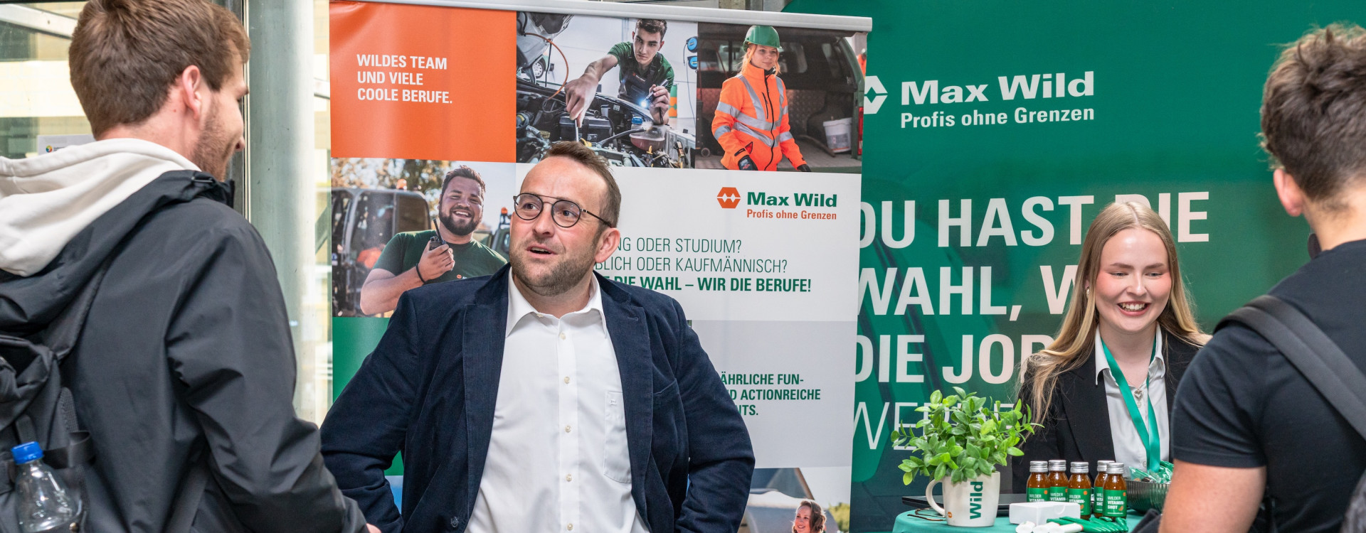 Menschen stehen an einem Messestand und lassen sich beraten