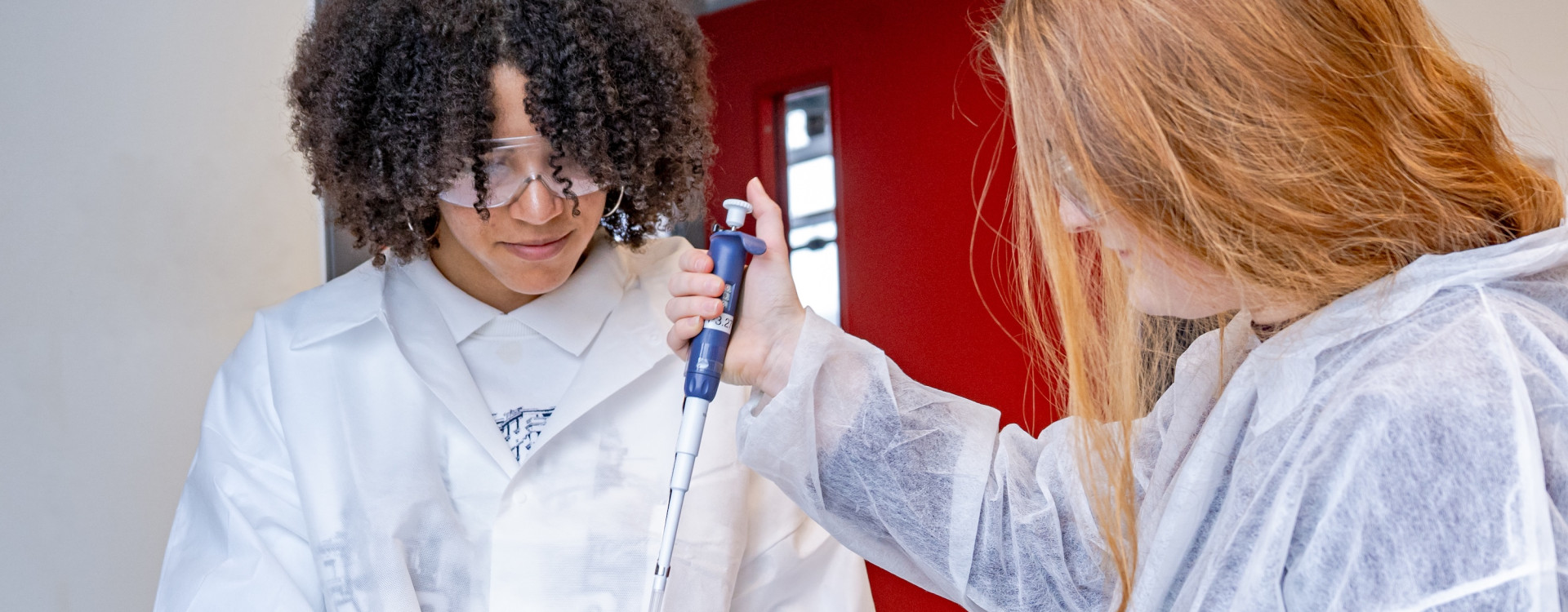 Zwei Schüler*innen führen einen Versuch durch im Labor