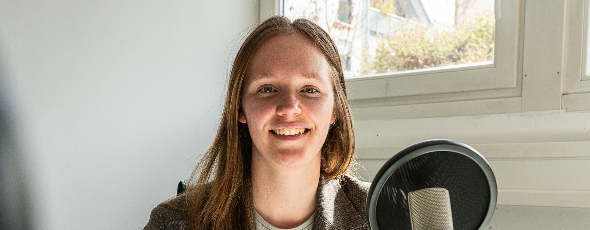 Frau im Porträt vor Mikrofon