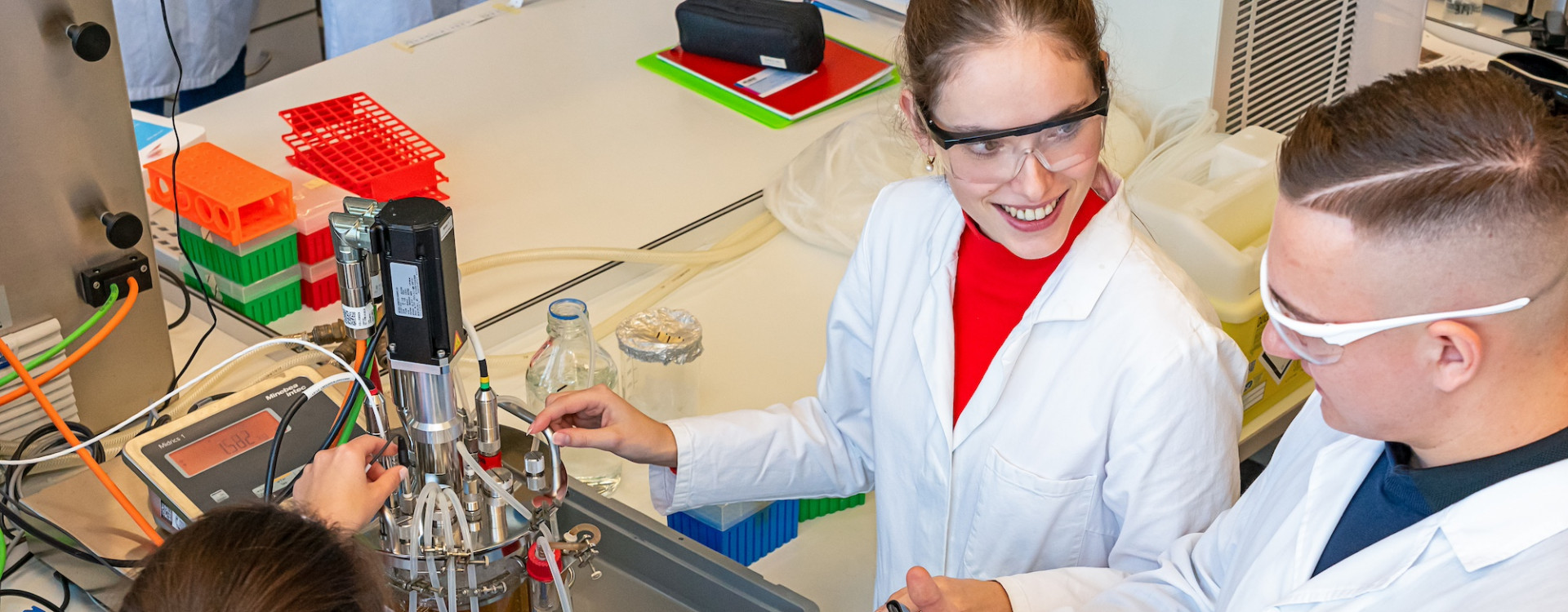 Drei junge Menschen beim Versuch im Labor