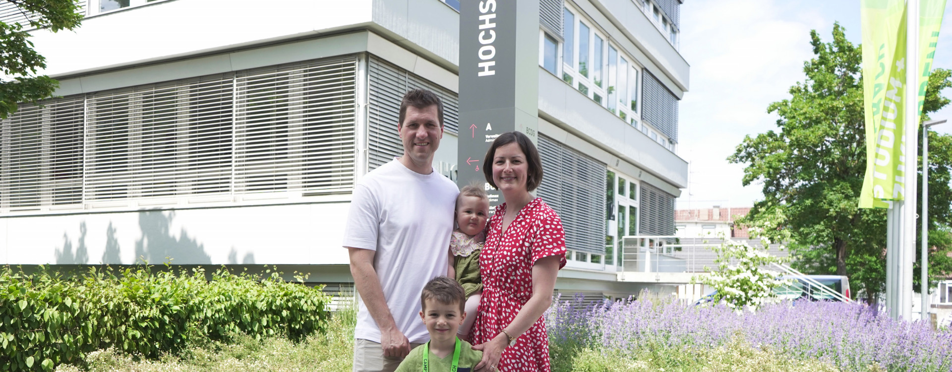 Mann, Frau und zwei Kinder vor Gebäude
