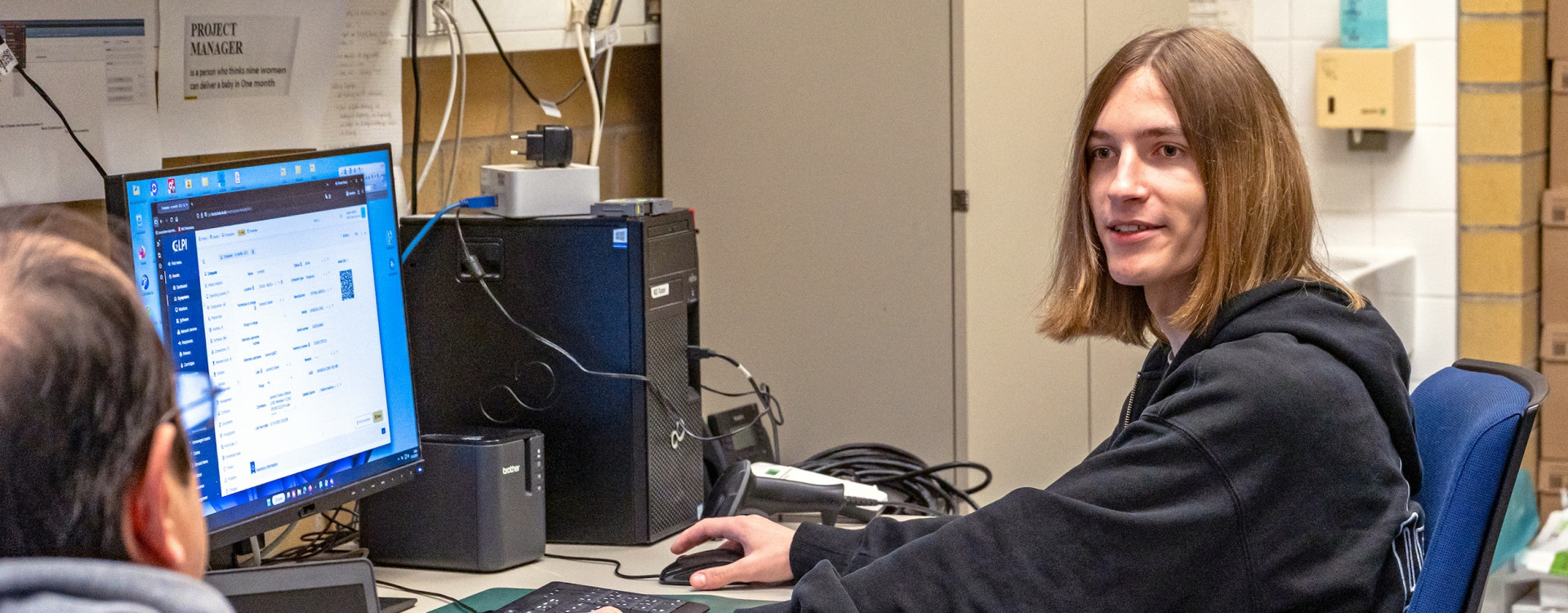 Ein junger Student sitzt vor einem Rechner