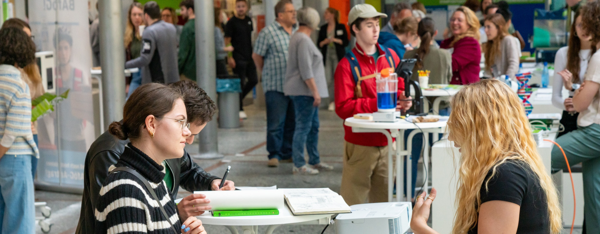 Zwei Personen lassen sich bei Infostand beraten
