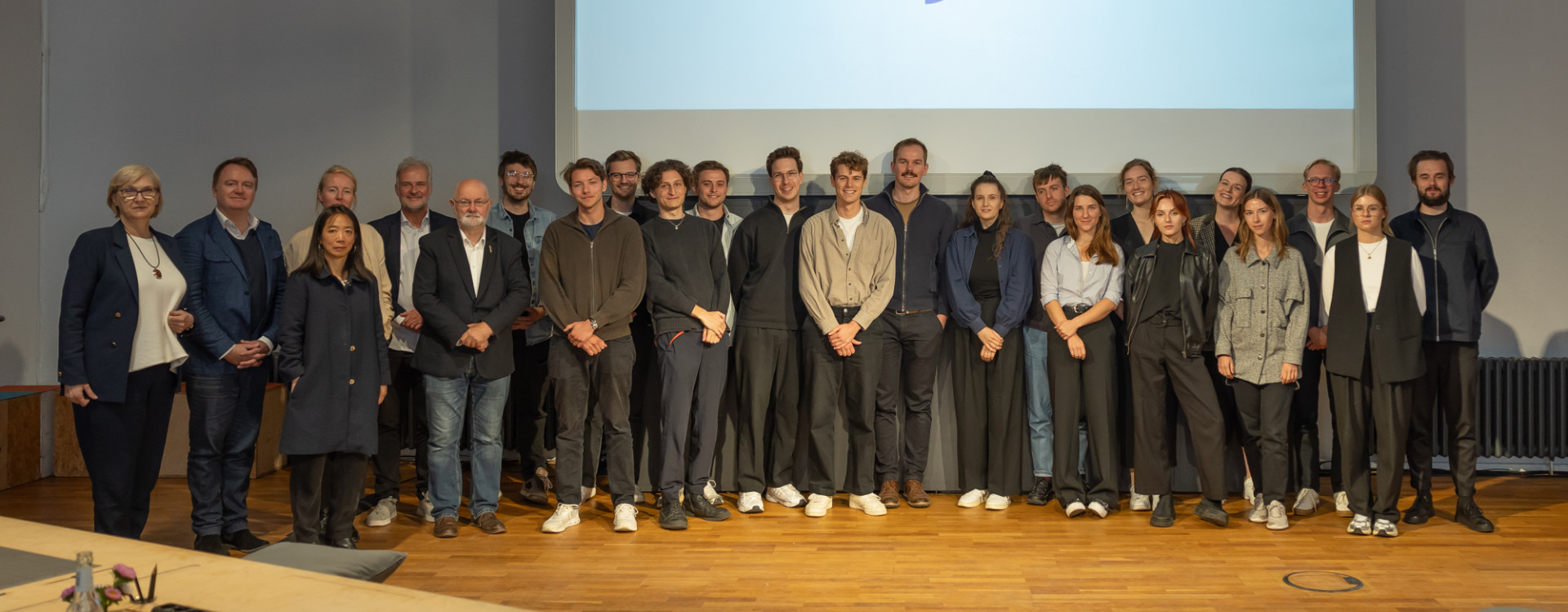 Viele Personen stehen bei einer Ehrung auf der Bühne