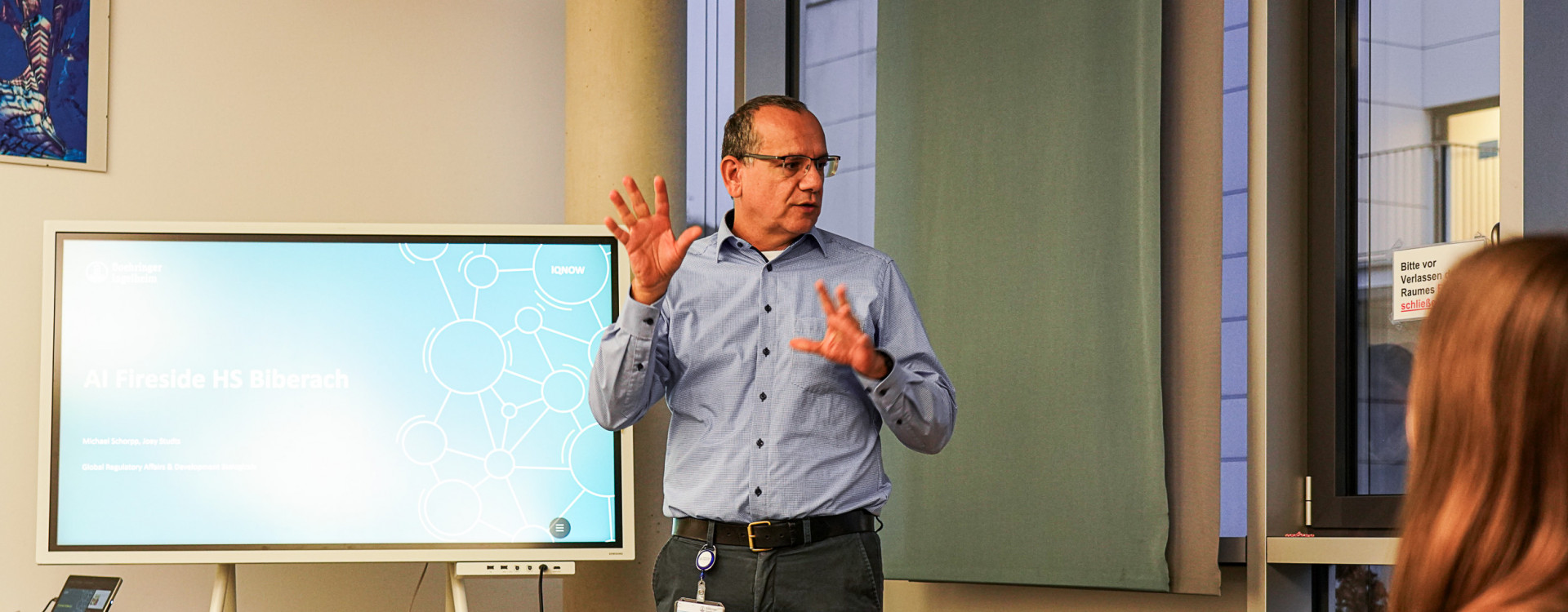 Mann steht vor einem Bildschirm und präsentiert