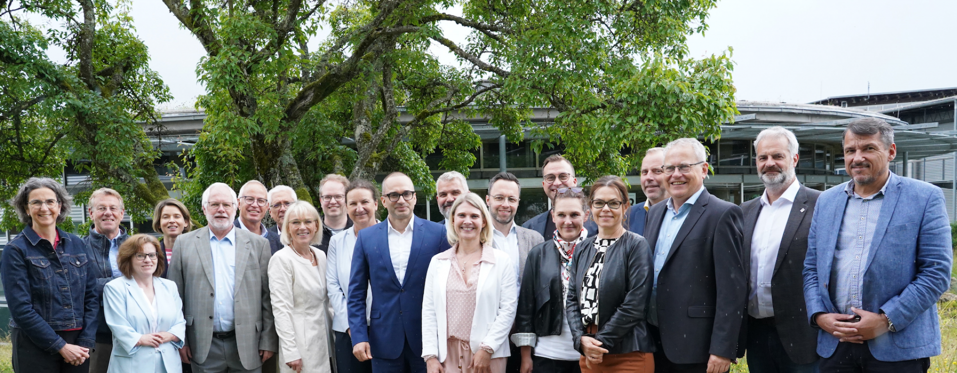 Viele Personen stehen draußen für ein Gruppenfoto