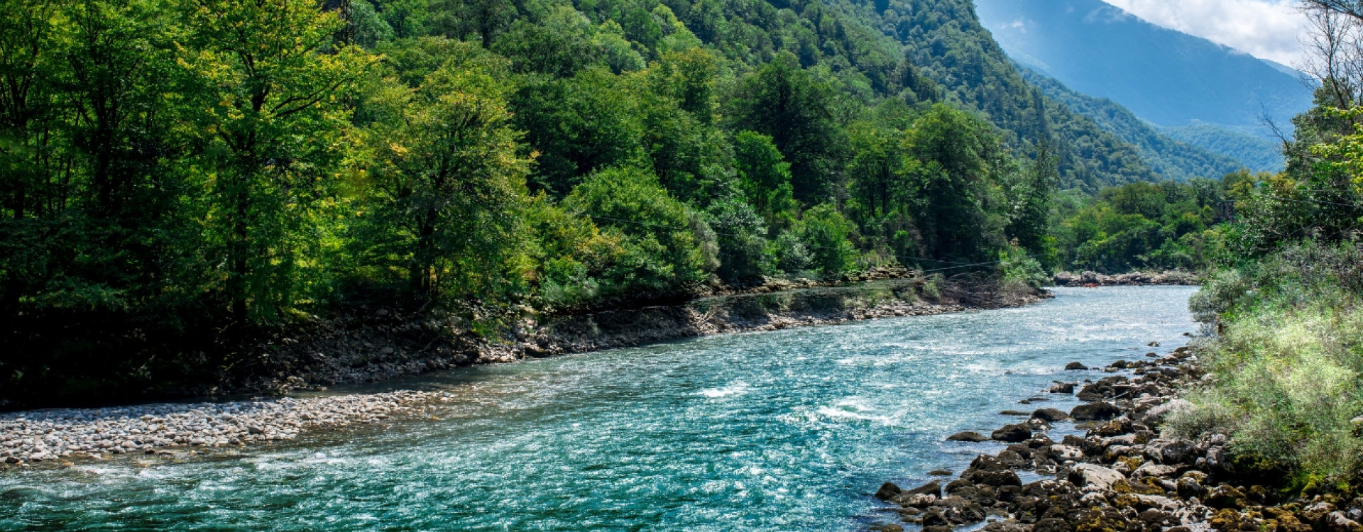Ein klarer Fluss fließt durch eine Berglandschaft