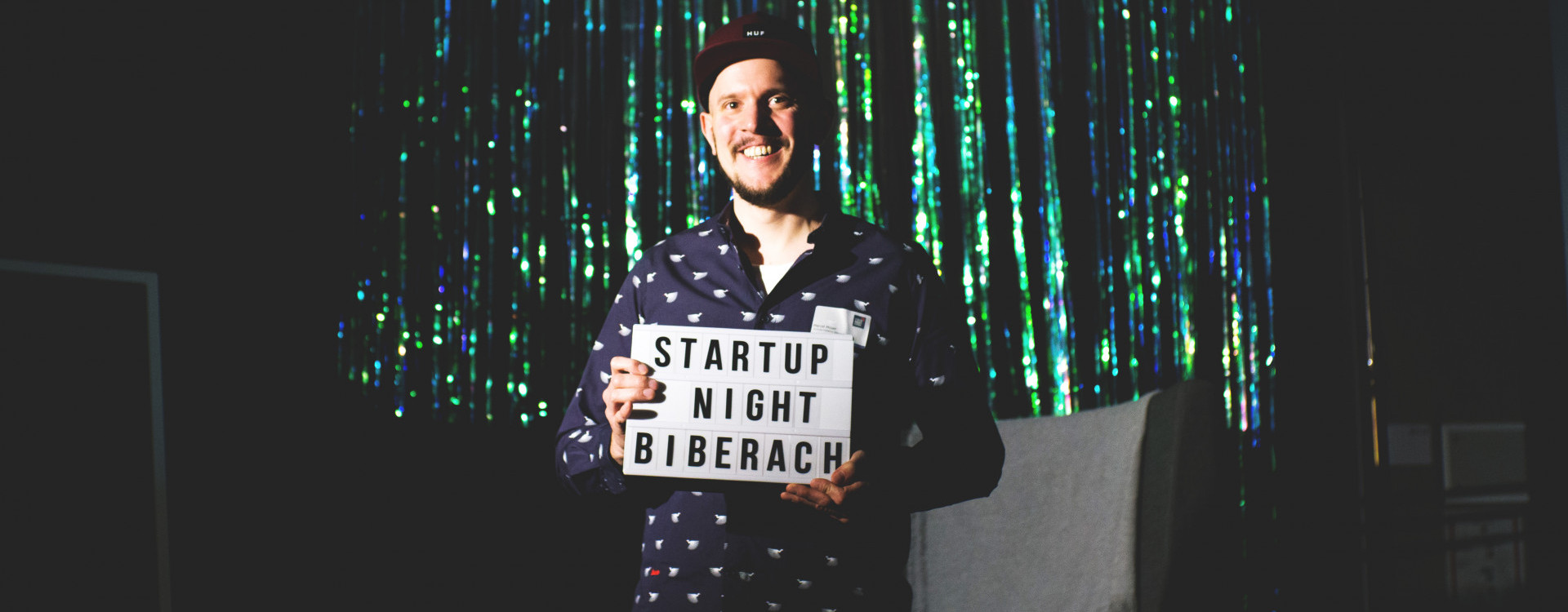 Mann mit Schild und Schriftzug &quot;Startup Night Biberach&quot;