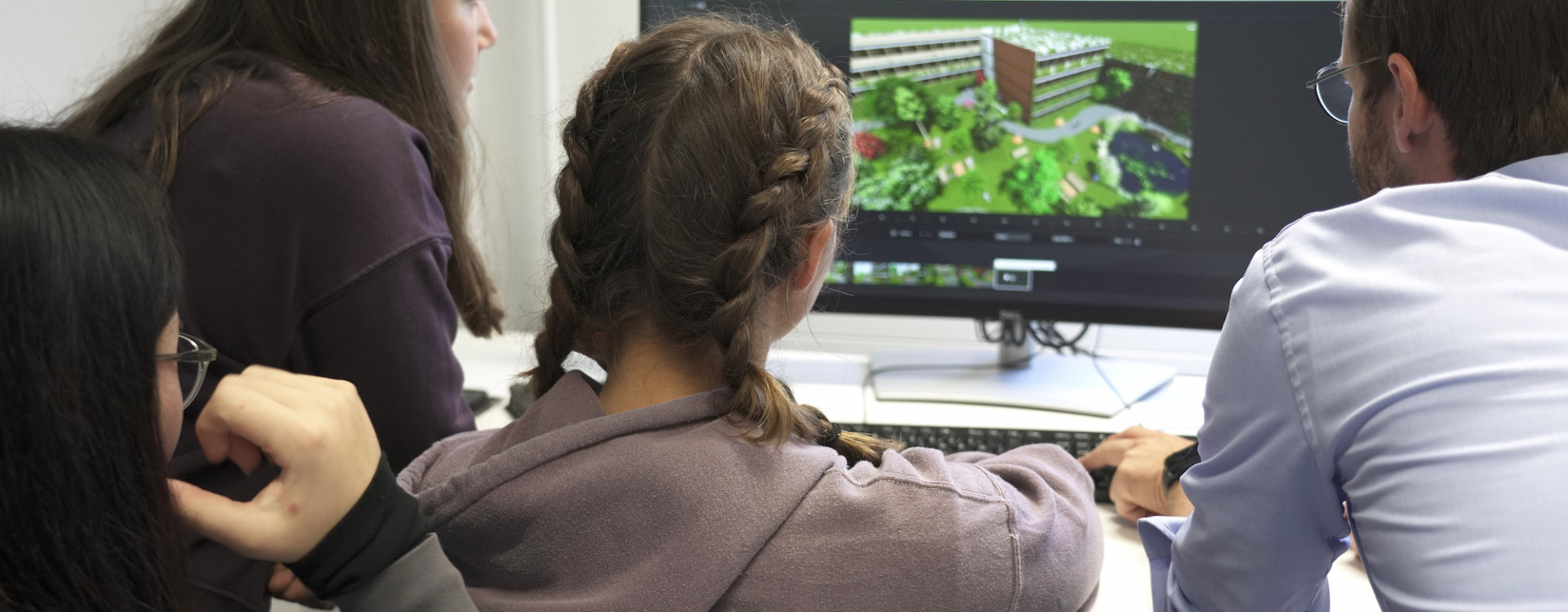 Schüler*innen vor einem PC