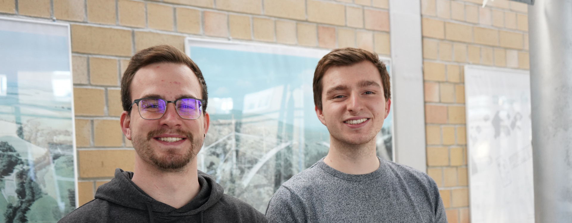 Zwei Studierende stehend vor Wand