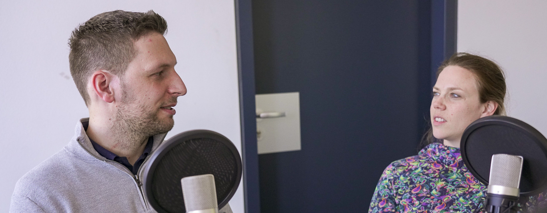 Zwei Personen unterhalten sich bei einer Podcastaufnahme
