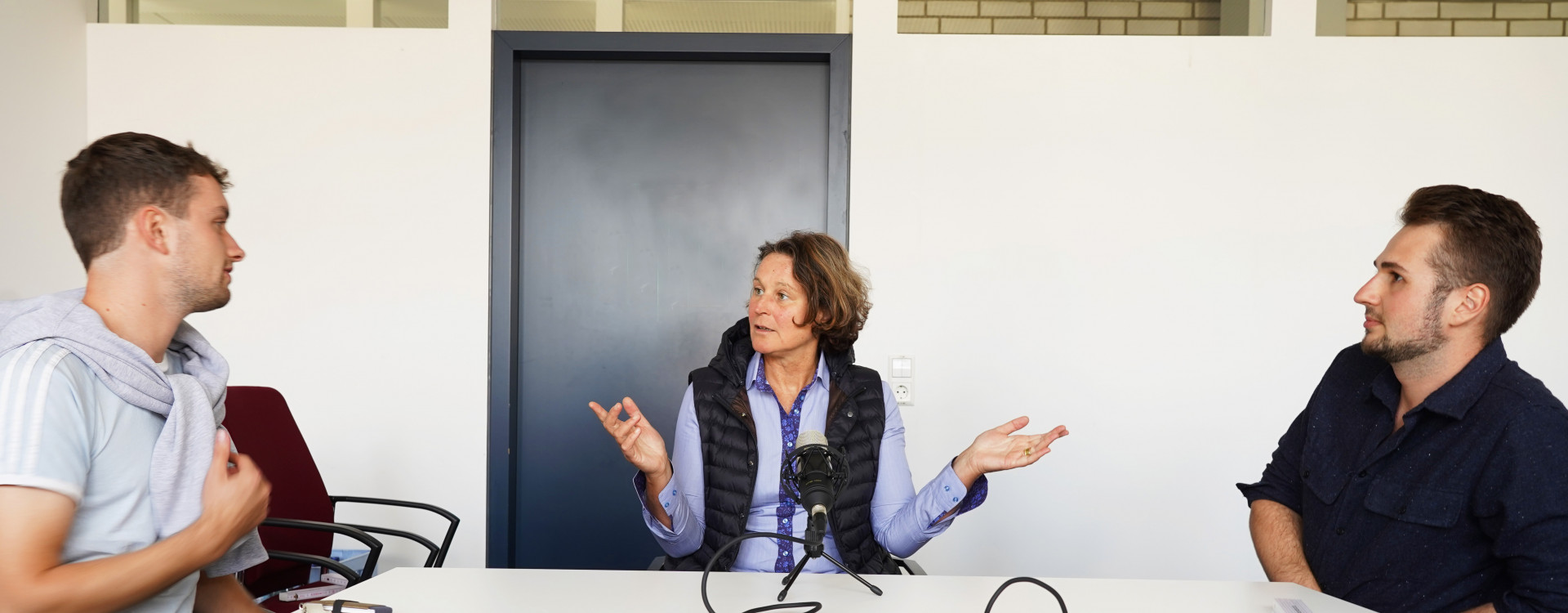 Drei Personen in einem Podcastgespräch
