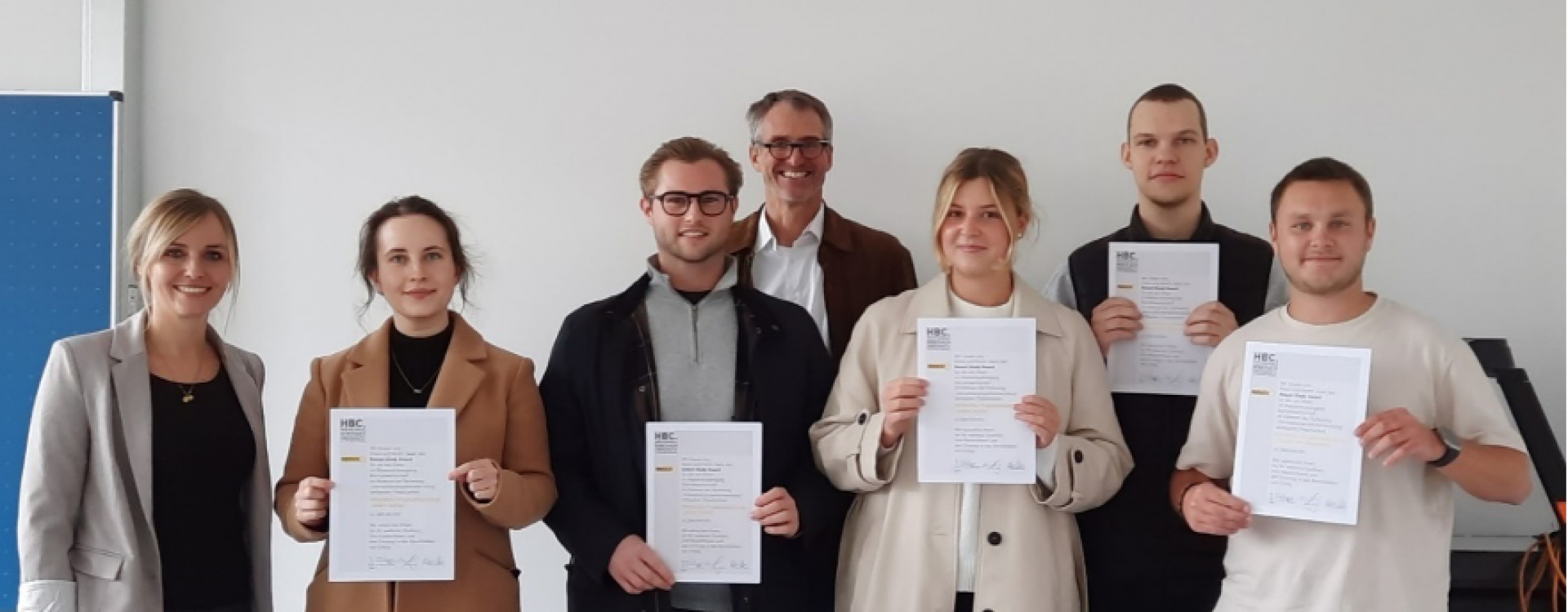 7 Personen mit Urkunden in der Hand