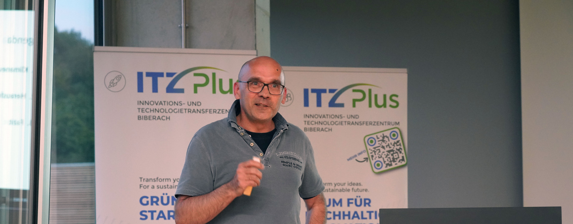 Mann mit Mikrofon hält Vortrag