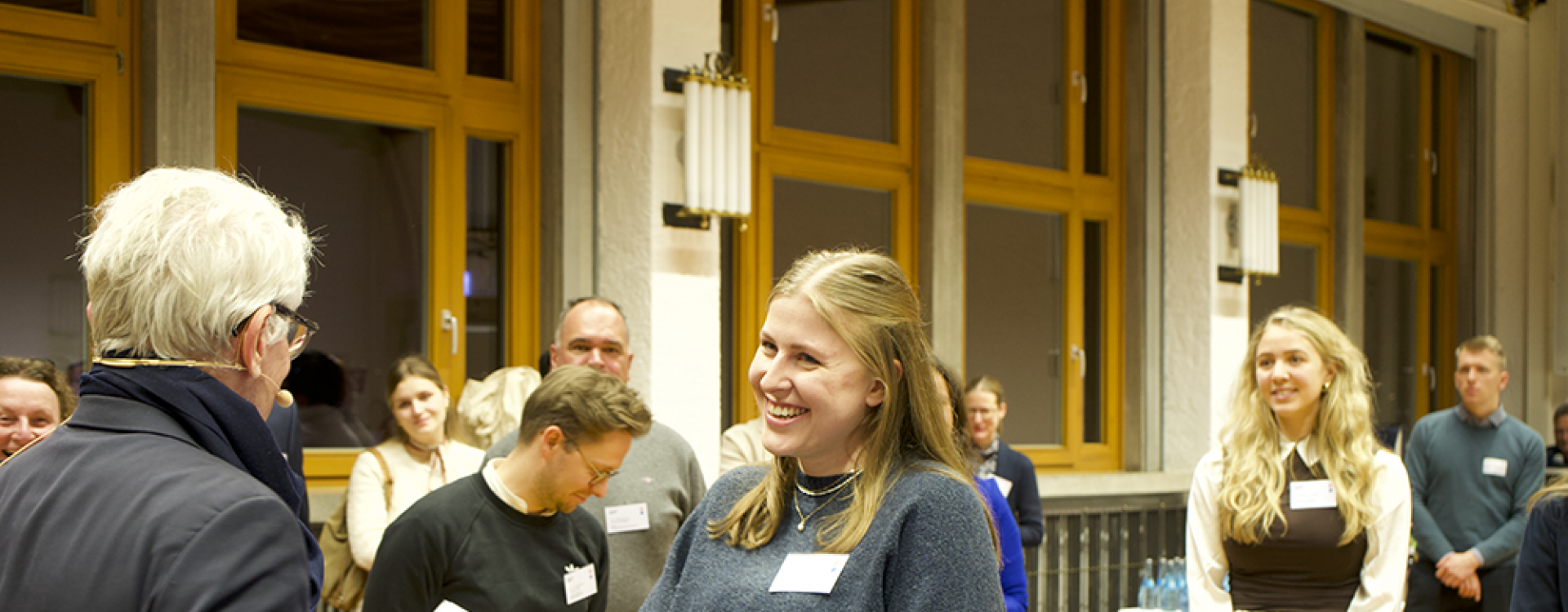 Mann übergibt Urkunde an Studentin