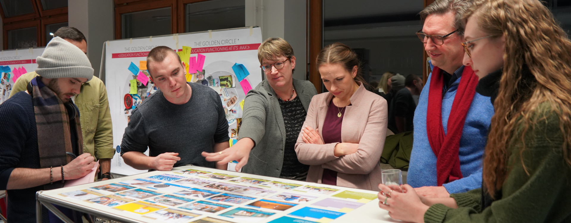 Gruppe um Tisch mit Kartenspiel stehend
