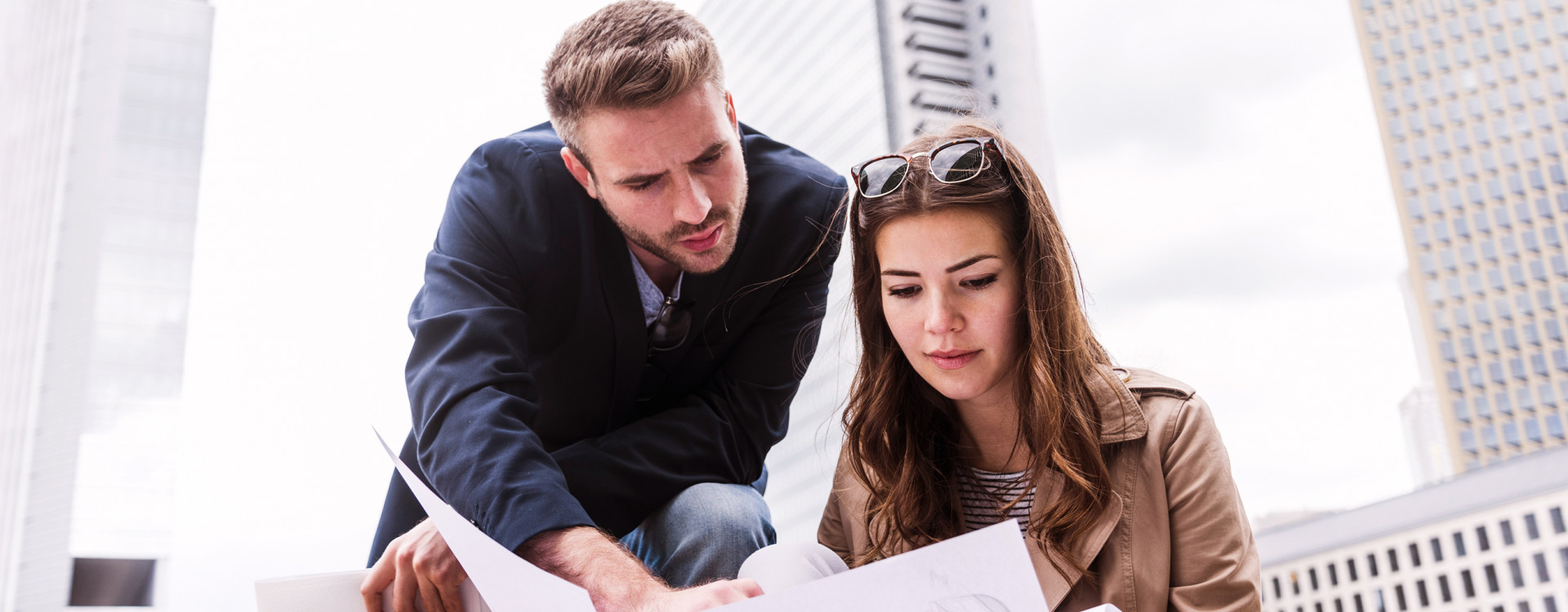 Ein Mann und eine Frau halten einen Bauplan