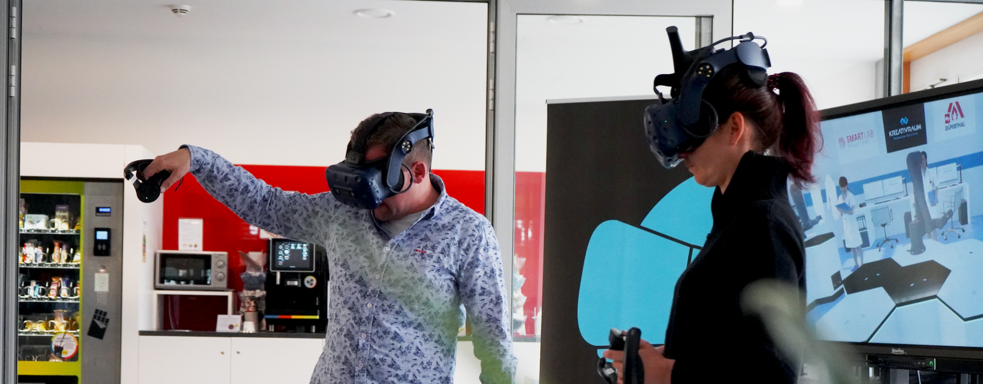 Zwei Personen (Mann und Frau) mit VR-Brillen