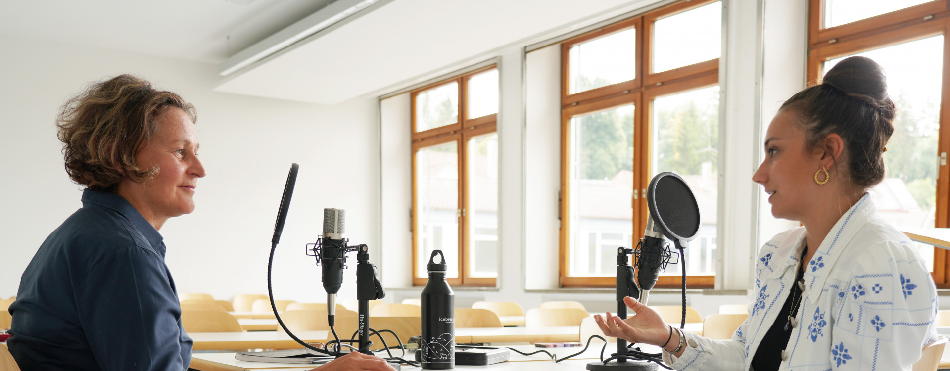 Zwei Frauen beim Podcast an einem Tisch