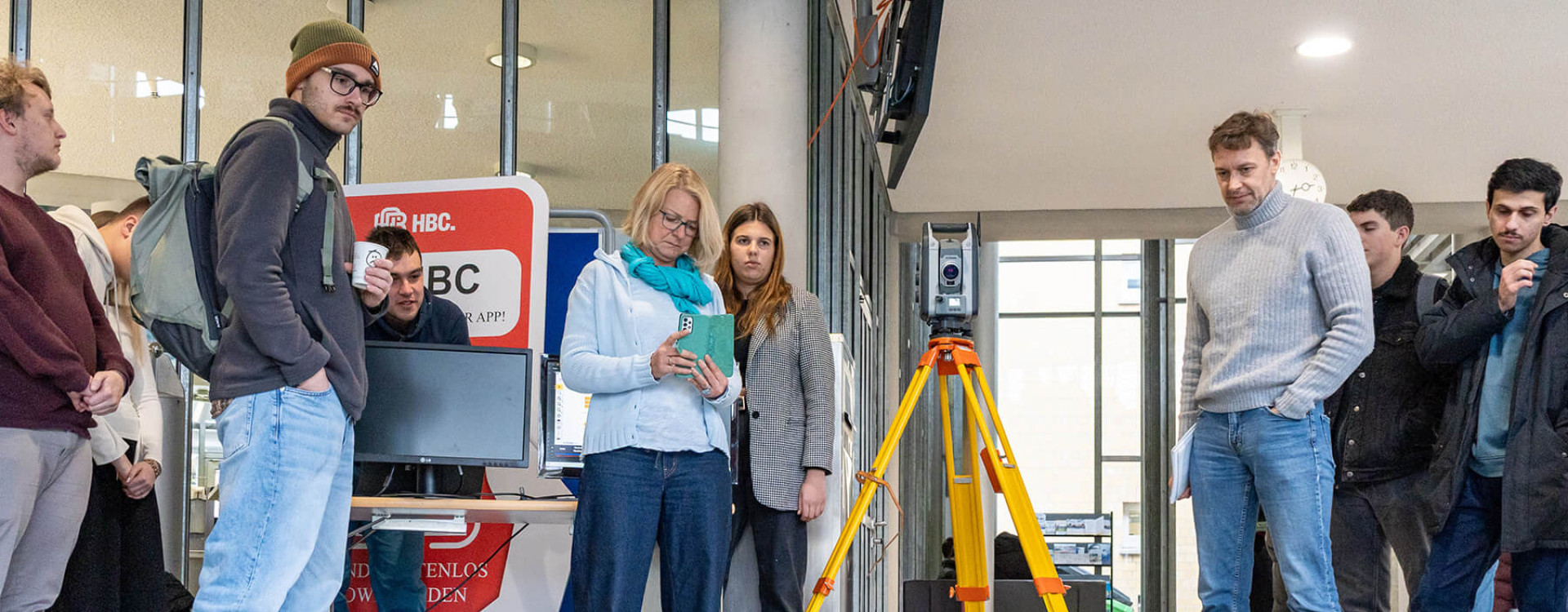 Eine Gruppe Studierender und Professor*innen steuert und filmt einen autonomen Roboter für die Baustelle