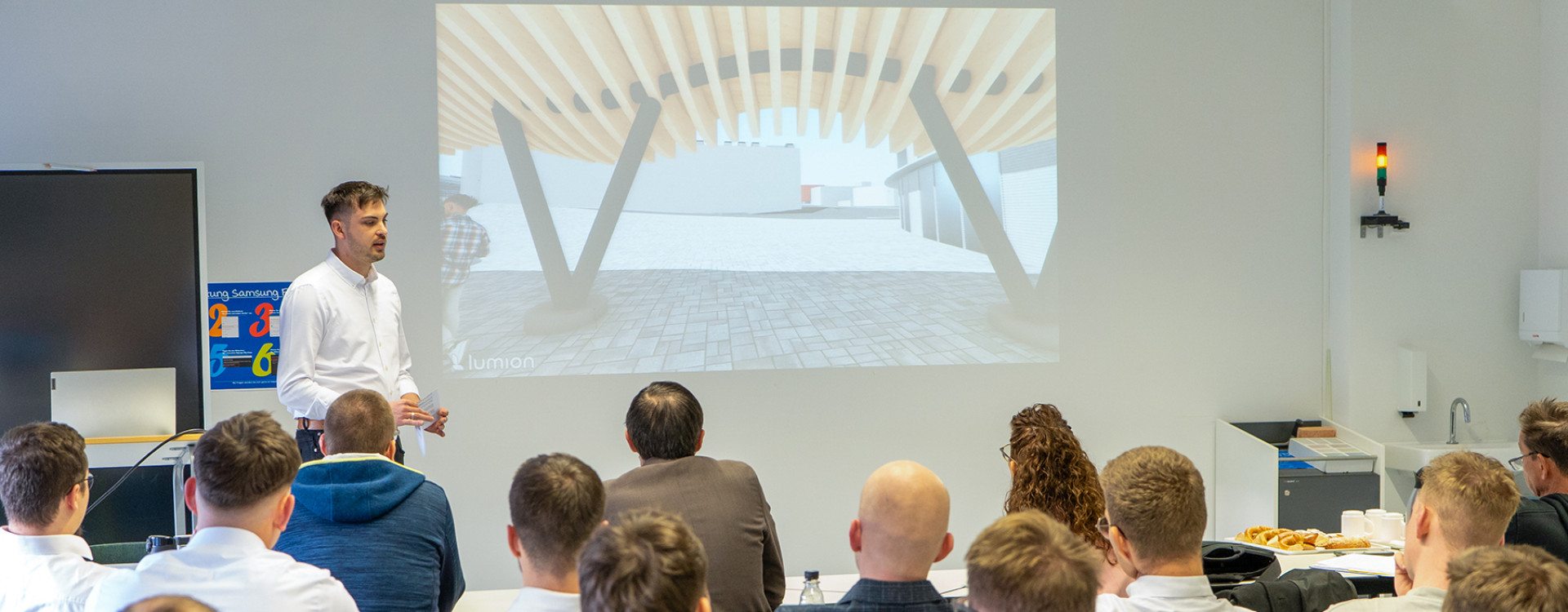 Studierender des Bau-Projektmanagement präsentiert seinen Entwurf im Plenum