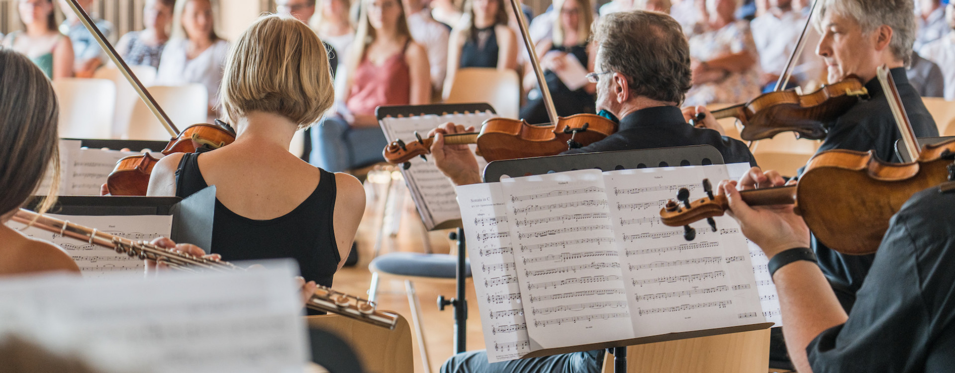 Orchester von hinten mit Einblick in Noten