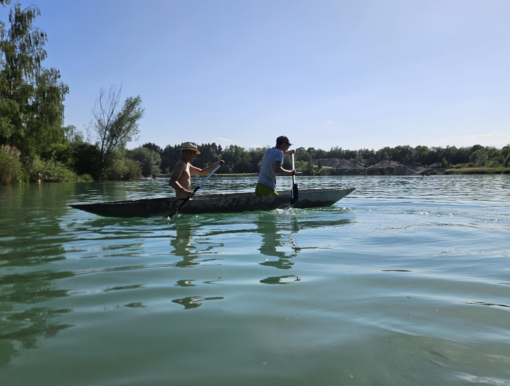 Zwei Männer in einem Betonkanu auf dem See
