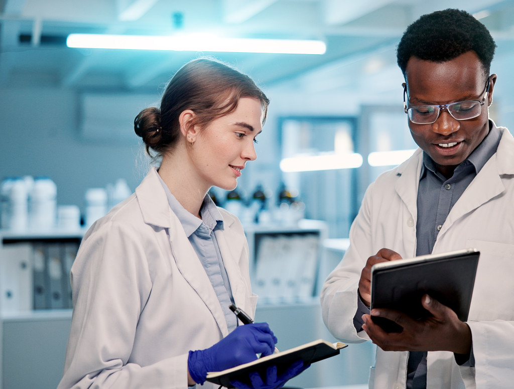 Ein Mann und eine Frau stehen im Labor mit Tablets in der Hand