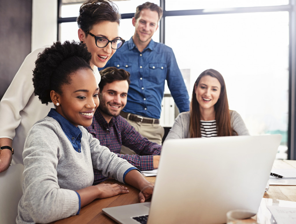 Fünf Personen verschiedener Nationalität sitzen vor einem Laptop