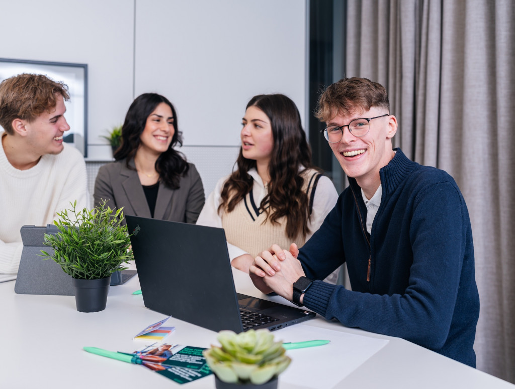 Vier junge Menschen sitzen an einem Tisch