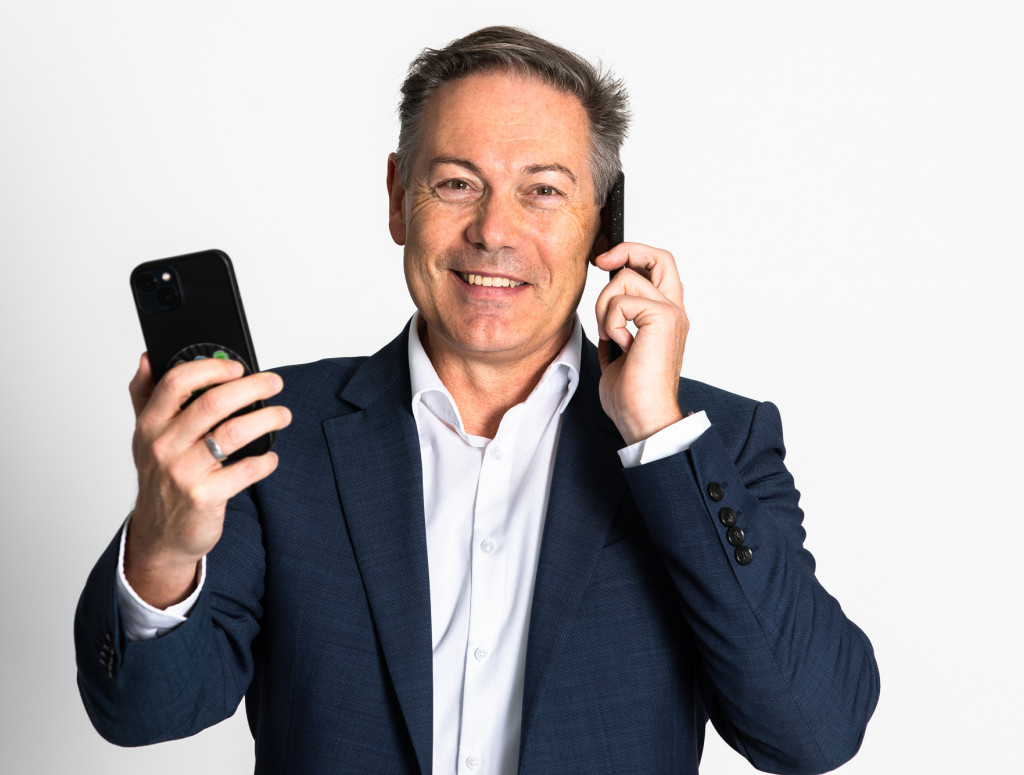 Porträt Mann mit zwei Handys in der Hand