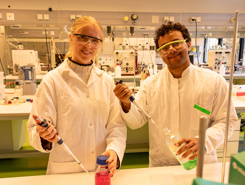 Eine junge Frau und ein junger Mann stehen im Labor und arbeiten