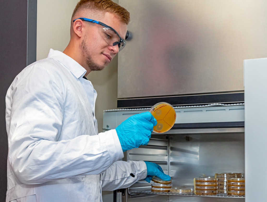 Junger Mann steht im Chemie-Labor