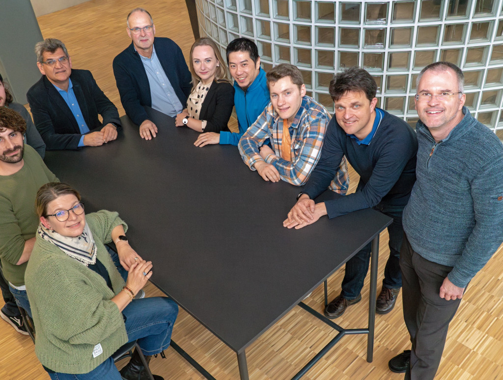 Gruppenbild mit 10 Personen rund um einen Tisch