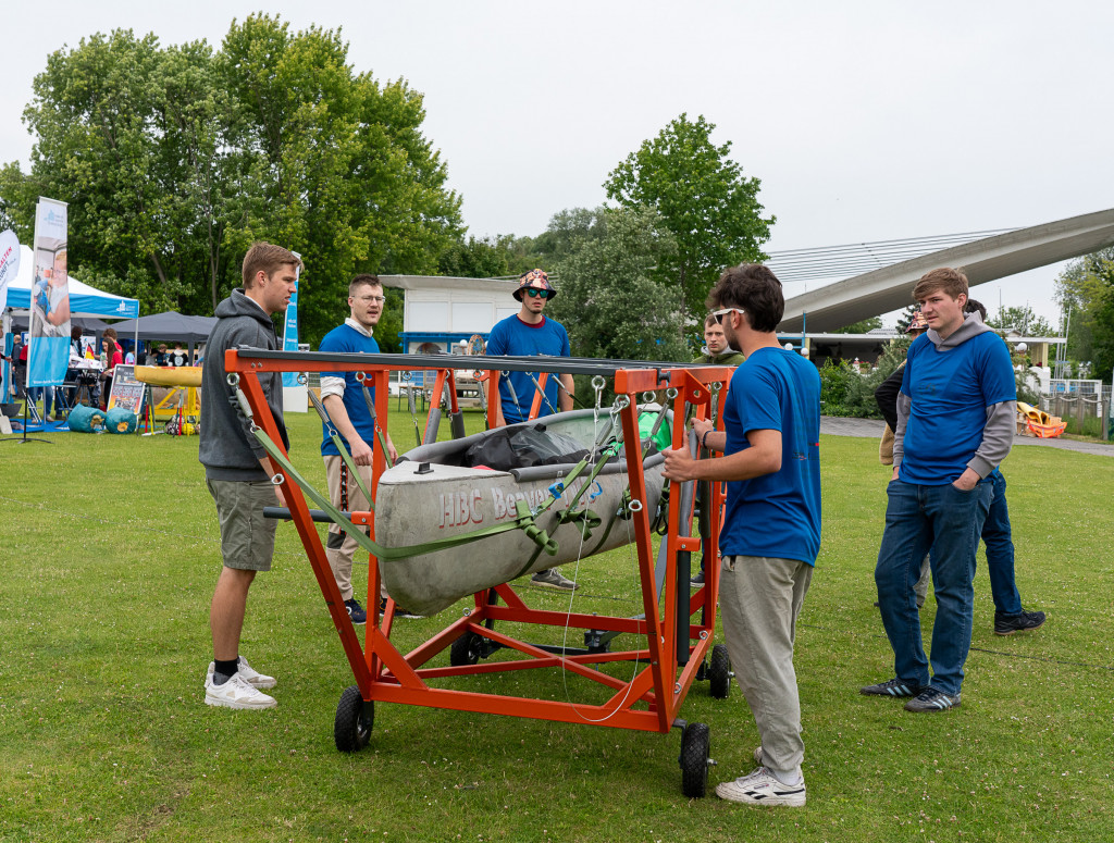 Männer stehen um ein Betonkanu herum