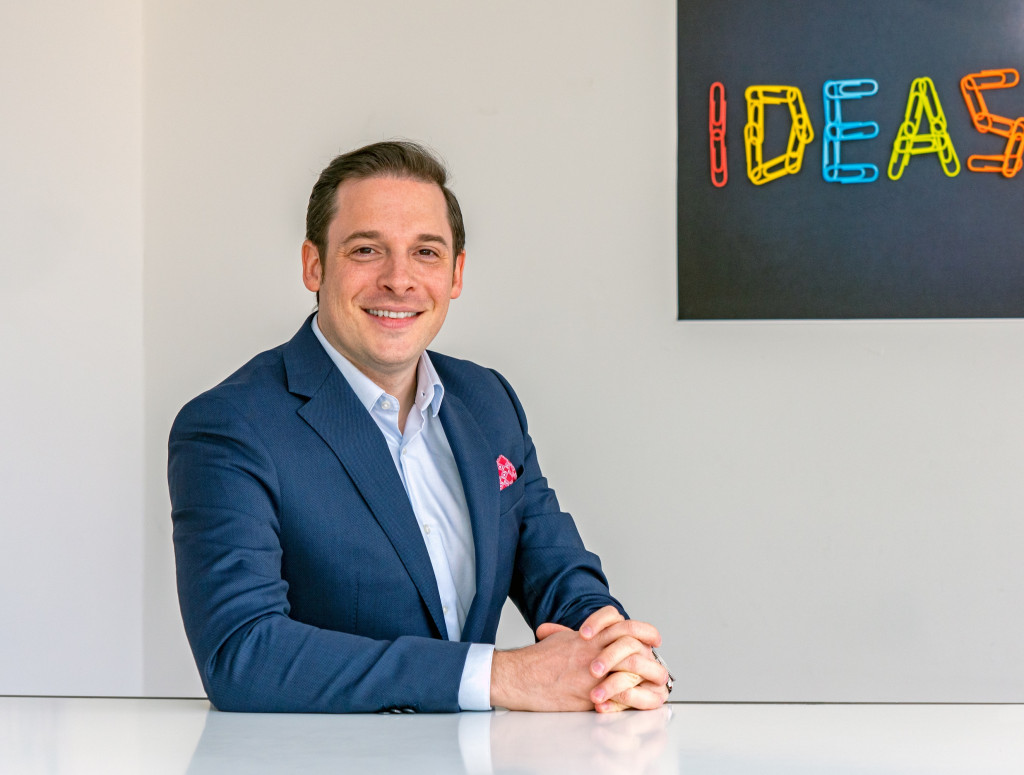 Mann im Anzug sitzt an einem weißen Tisch