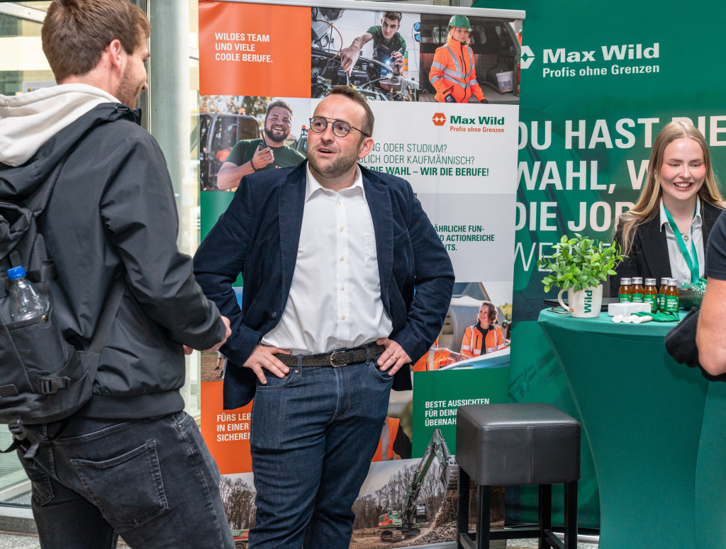 Menschen stehen an einem Messestand und lassen sich beraten