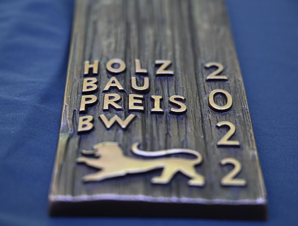 Holzbrett mit Aufschrift Holzbaupreis BW 2022; Auszeichnung