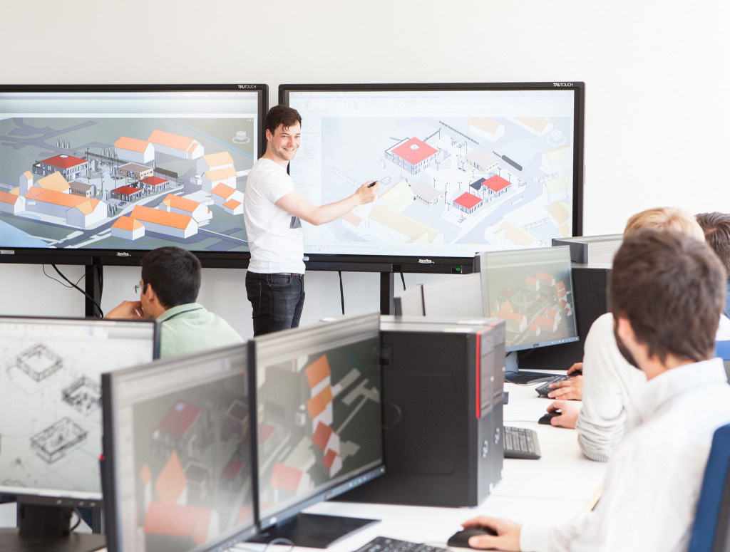 Student präsentiert vor einem digitalen Monitor