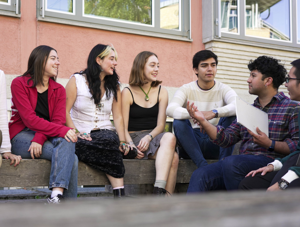 Studierende aus verschiedenen Nationen sitzen draußen