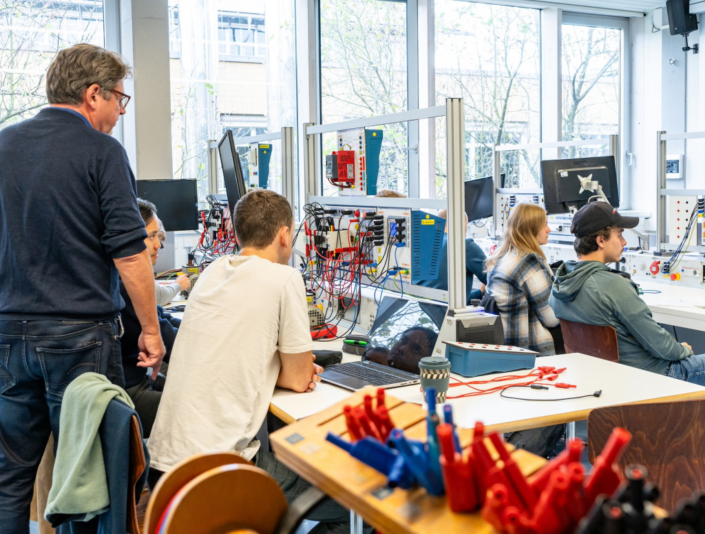 Personen sitzen in einem Labor für elektrische Systeme