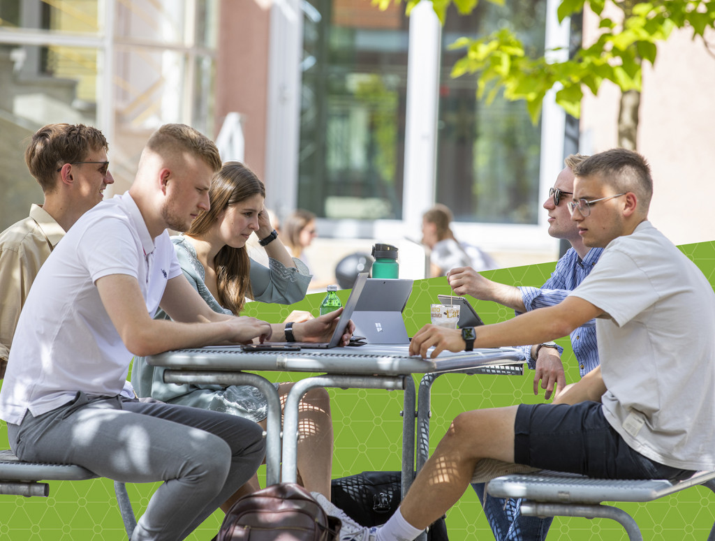 Studierende bei Gruppenarbeit an einem Tisch