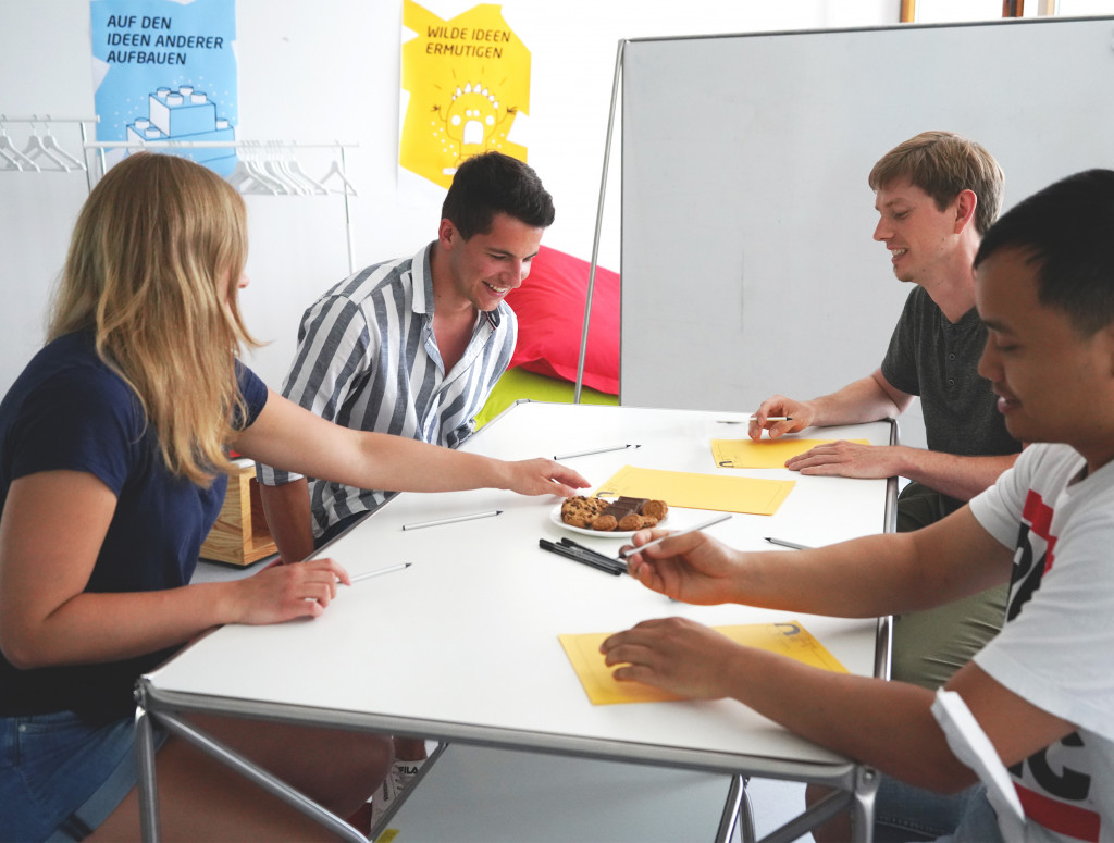 Studierende an einem Tisch bei Gruppenarbeit