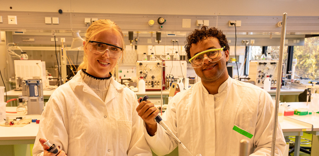 Eine junge Frau und ein junger Mann stehen im Labor und arbeiten