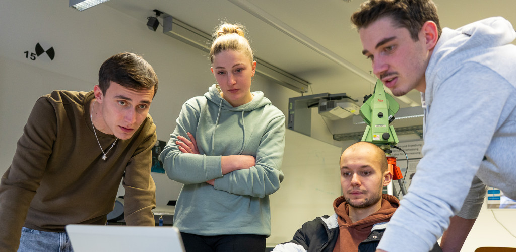 Vier Studierende arbeiten an einem Laptop