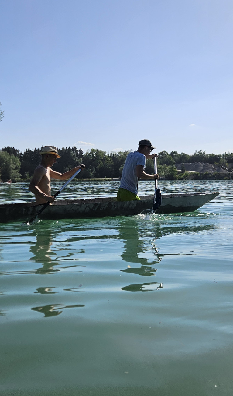 Zwei Männer in einem Betonkanu auf dem See