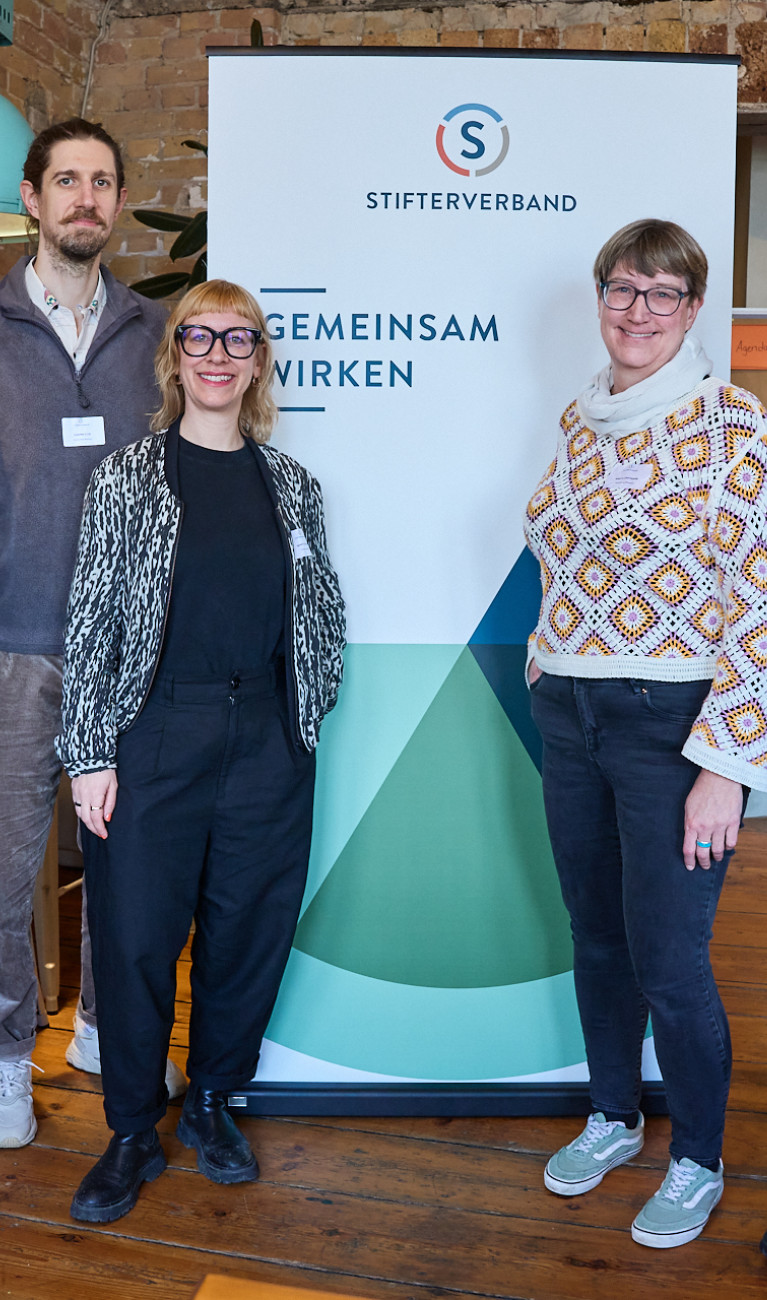 Fünf Personen stehen vor einem Banner