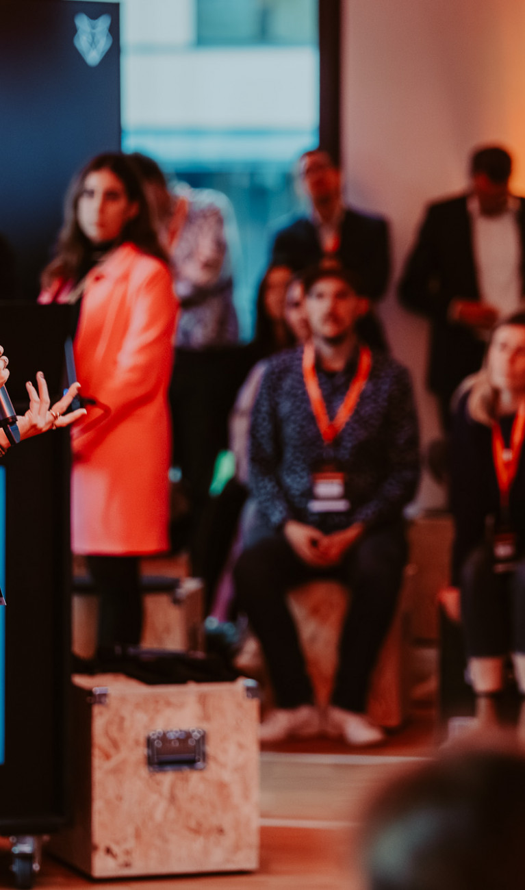 Eine Frau steht auf einer Bühne und präsentiert